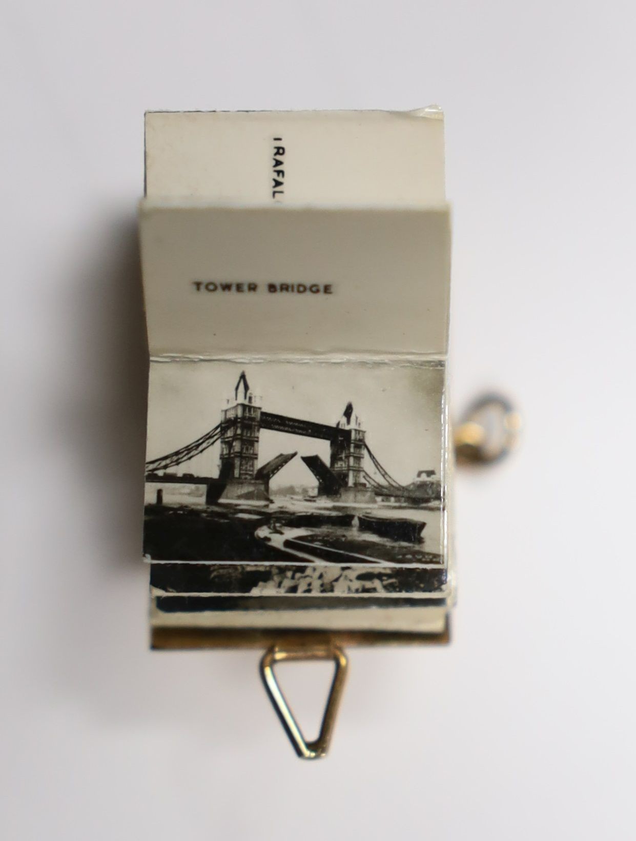 An enamelled 9ct gold photograph album charms with views and crest of London, 1.5cm gross 3.1 grams